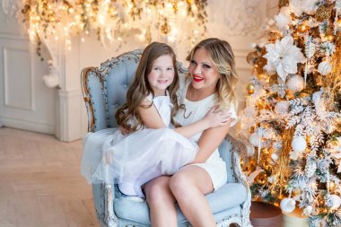 Anne ve kızı evde Noel ağacı yakınında oynarken dinlenmek