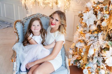 Anne ve kızı evde Noel ağacı yakınında oynarken dinlenmek