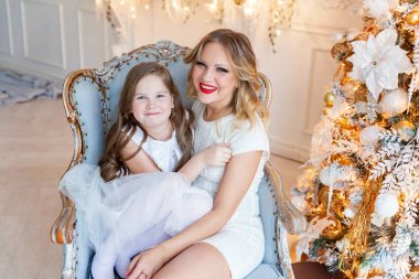 Anne ve kızı evde Noel ağacı yakınında oynarken dinlenmek