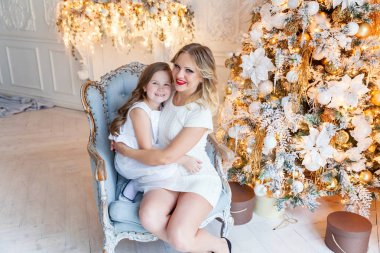 Anne ve kızı evde Noel ağacı yakınında oynarken dinlenmek