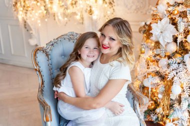 Anne ve kızı evde Noel ağacı yakınında oynarken dinlenmek