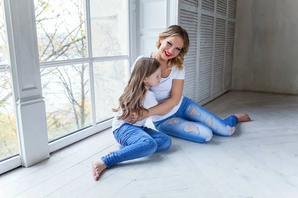 Mutlu aile kadın anne ve küçük kız windiow yakın yatak odasında sarılma oynarken dinlenmek — Stok fotoğraf