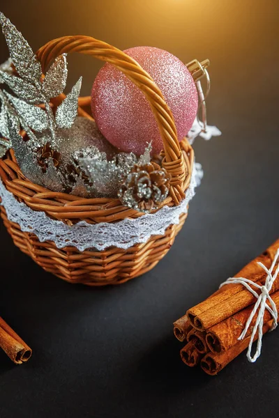 Basket with Christmas decorations on black background