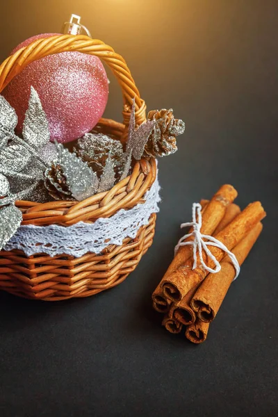 Basket with Christmas decorations on black background