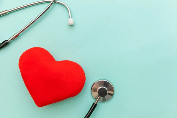 Medicine equipment stethoscope or phonendoscope and red heart isolated on trendy pastel blue background. Instrument device for doctor. Health care life insurance concept — Stock Photo, Image