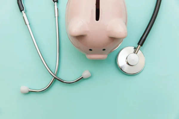 Medicine doctor equipment stethoscope or phonendoscope and piggy bank isolated on trendy pastel blue background