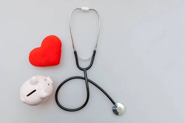 Medicine doctor equipment stethoscope or phonendoscope piggy bank and red heart isolated on white background — Stock Photo, Image