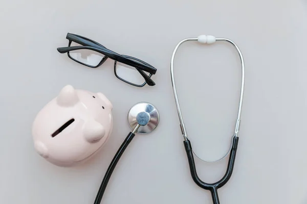 Equipamento médico medicina estetoscópio ou fonendoscópio óculos de banco piggy isolado em fundo branco — Fotografia de Stock