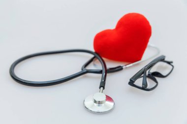 Tıbbi ekipman stetoskop veya fonndoskop gözlük ve kırmızı kalp beyaz arka plan üzerinde izole. Doktor için alet cihazı. Sağlık hayat sigortası kavramı