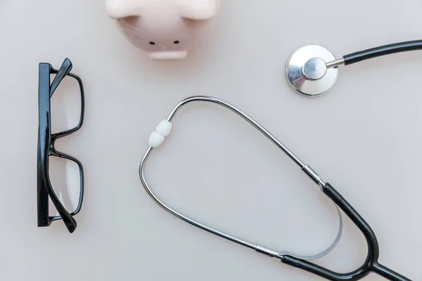 Medicine doctor equipment stethoscope or phonendoscope piggy bank glasses isolated on white background