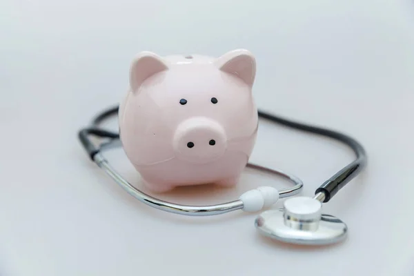 Medicina equipamento médico estetoscópio ou fonendoscópio e porquinho banco isolado em fundo branco — Fotografia de Stock