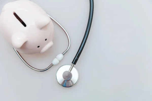 Medycyna lekarz sprzęt stetoskop lub fonendoskop i Piggy Bank izolowane na białym tle — Zdjęcie stockowe