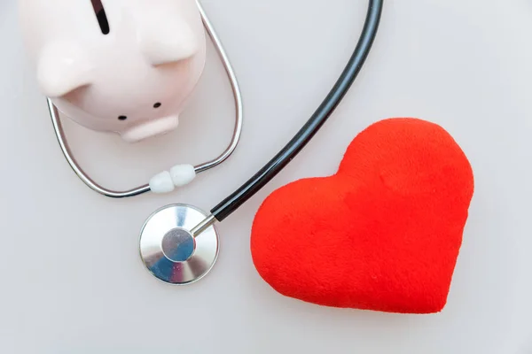 Medicine doctor equipment stethoscope or phonendoscope piggy bank and red heart isolated on white background