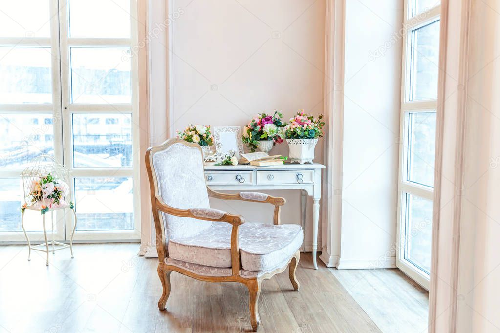 Beautiful white bright clean interior bedroom with large window, armchair in luxurious baroque style