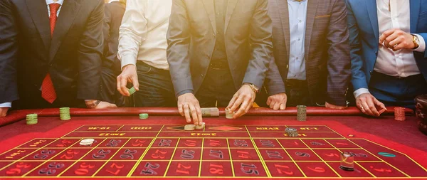 Grupo de personas detrás de la mesa de juego de ruleta en banner de casino de lujo — Foto de Stock