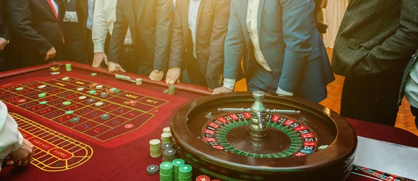 Grupo de personas detrás de la mesa de juego de ruleta en banner de casino de lujo — Foto de Stock