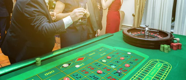 Grupp människor bakom Roulette spelbord i lyx Casino banner — Stockfoto