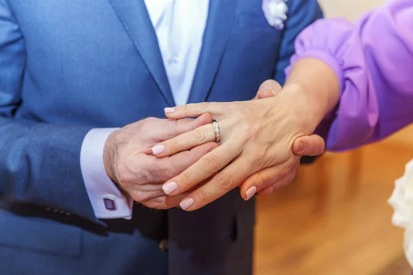 Brudgummen hand sätta vigselringen på bruden finger — Stockfoto