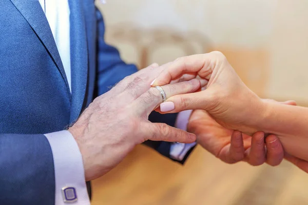 Bruden hand sätta vigselringen på brudgummen finger — Stockfoto