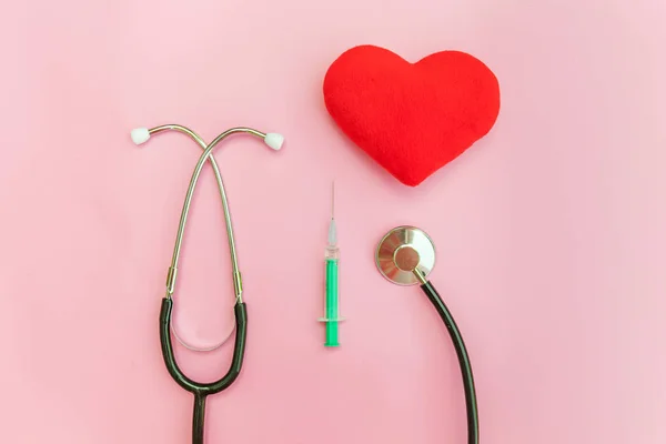 Equipamento de medicina estetoscópio ou seringa de fonendoscópio e coração vermelho isolado no moderno fundo rosa pastel — Fotografia de Stock