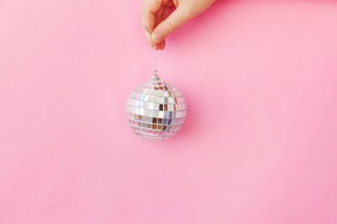 Sadece minimal tasarım kadın kadın el tutan Noel süs topu pembe pastel renkli trendy arka plan izole