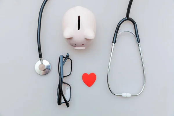 Medicine doctor equipment stethoscope or phonendoscope piggy bank glasses isolated on white background