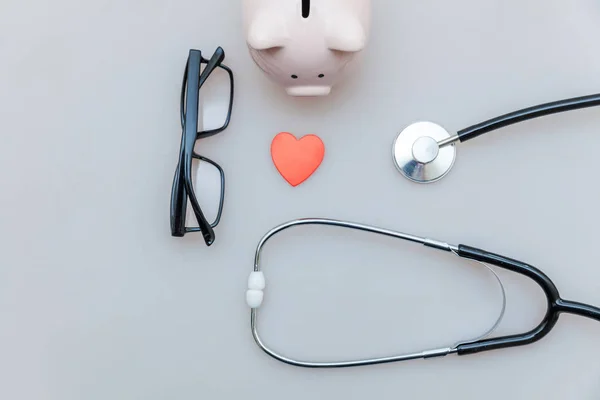 Medicine doctor equipment stethoscope or phonendoscope piggy bank glasses isolated on white background — Stock Photo, Image