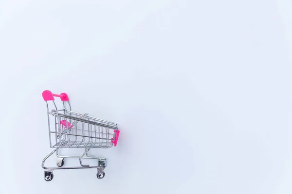 Piccolo carrello di spinta del giocattolo del supermercato del supermercato su sfondo bianco — Foto Stock