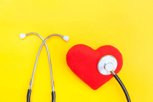 Equipamento de medicina estetoscópio ou fonendoscópio e coração vermelho isolado no fundo amarelo da moda — Fotografia de Stock