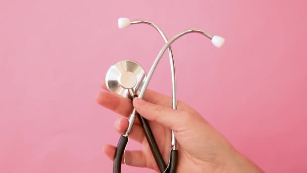 简约设计的女用手持医疗设备听诊器或留声机 在流行的粉红背景上隔离 医生用的仪器装置 保健人寿保险概念 — 图库视频影像