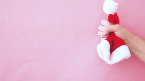 간단하게 디자인 분홍색 파스텔 배경에서 크리스마스 모자를 누르고 크리스마스 새해는 — 비디오