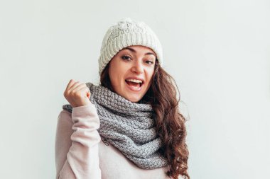 Beyaz arka planda izole sıcak giysiler şapka ve eşarp giyen Gülen kız
