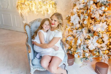 Anne ve kızı evde Noel ağacı yakınında oynarken dinlenmek