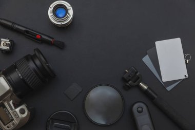 DSLR kamera sistemi, kamera Temizleme Kiti, koyu siyah masa arka planda objektif ve kamera aksesuarı ile fotoğrafçı çalışma alanı
