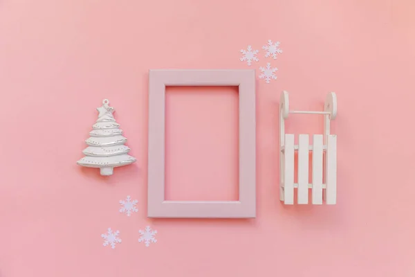 Simplesmente composição mínima objetos de inverno quadro rosa ornamento abeto árvore trenó isolado no fundo da moda pastel rosa — Fotografia de Stock