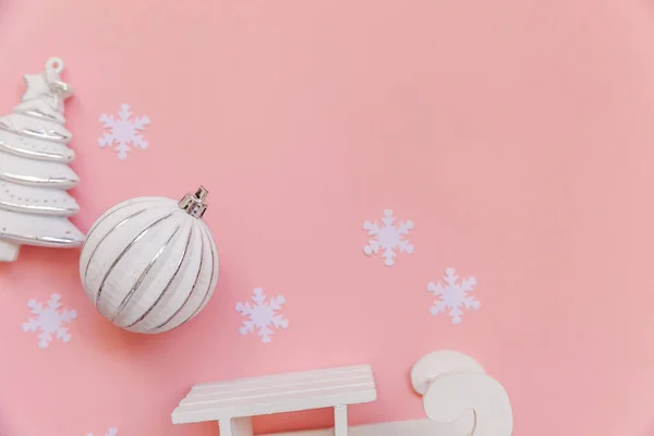 Simplesmente composição mínima objetos de inverno ornamento bola abeto árvore trenó isolado no fundo da moda pastel rosa — Fotografia de Stock
