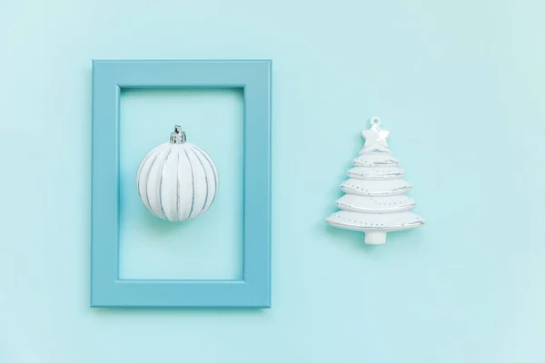 Simplesmente composição mínima objetos de inverno ornamento bola de abeto na moldura azul isolado no fundo da moda pastel azul — Fotografia de Stock