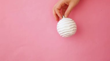 Sadece minimal tasarım kadın kadın el tutan Noel süs topu pembe pastel renkli trendy arka plan izole