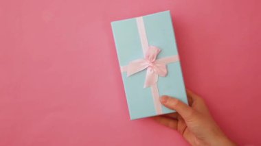 Sadece tasarım kadın kadın el tutan mavi hediye kutusu pembe pastel renkli trendy arka plan izole