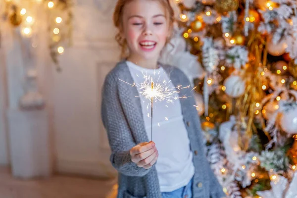 Menina com sparkler perto da árvore de Natal em casa — Fotografia de Stock