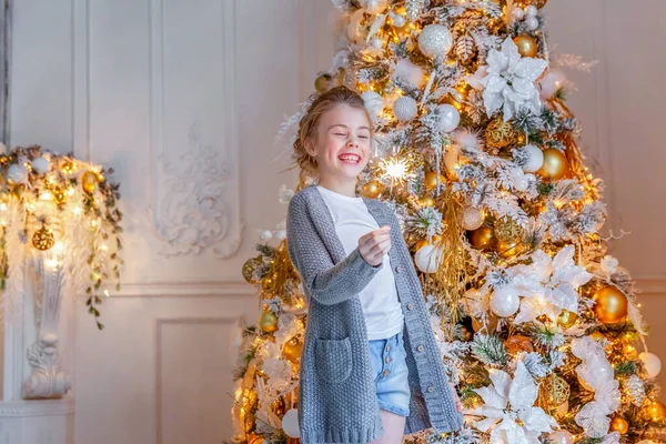 Holčička s jiskřičkou u vánočního stromečku doma — Stock fotografie