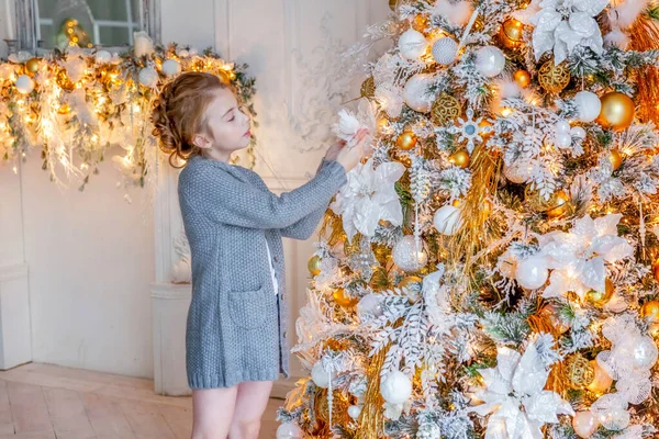 Девочка украшает рождественскую ёлку дома — стоковое фото