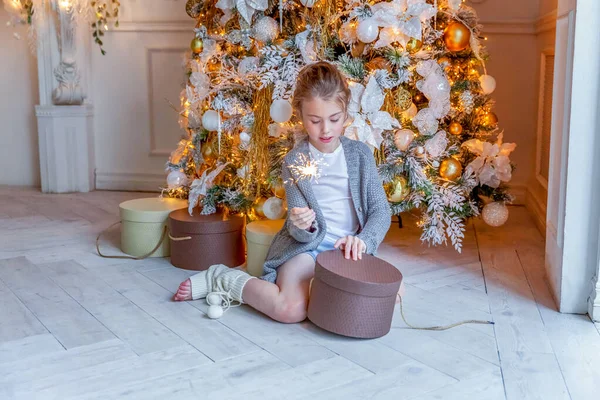 Κοριτσάκι με σπίθα κοντά στο χριστουγεννιάτικο δέντρο στο σπίτι — Φωτογραφία Αρχείου