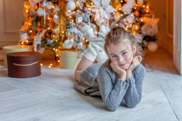 Menina com caixa de presente perto da árvore de Natal em casa — Fotografia de Stock