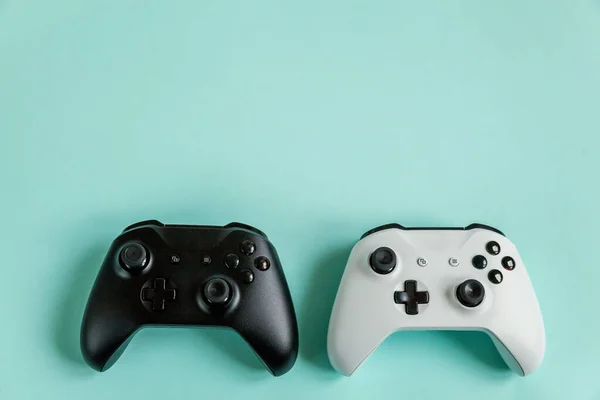 Branco e preto dois joystick gamepad, console de jogo isolado em pastel azul colorido fundo da moda — Fotografia de Stock