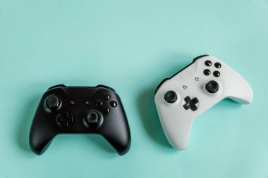 Beyaz ve siyah iki oyun sahası, oyun konsolu pastel mavi renkli arka planda izole edilmiş