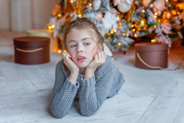 Kleines Mädchen mit Geschenkbox in der Nähe des Weihnachtsbaums zu Hause — Stockfoto