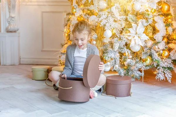 Κοριτσάκι με κουτί δώρου κοντά στο χριστουγεννιάτικο δέντρο στο σπίτι — Φωτογραφία Αρχείου