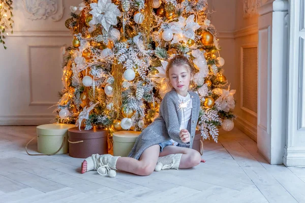 Holčička s jiskřičkou u vánočního stromečku doma — Stock fotografie