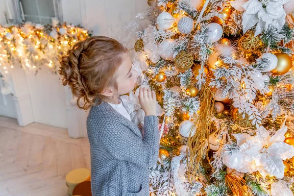 Девочка украшает рождественскую ёлку дома — стоковое фото